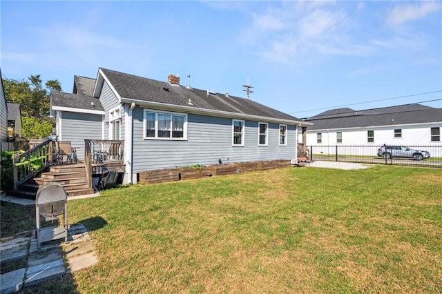 rear view of property featuring a wooden deck and a lawn