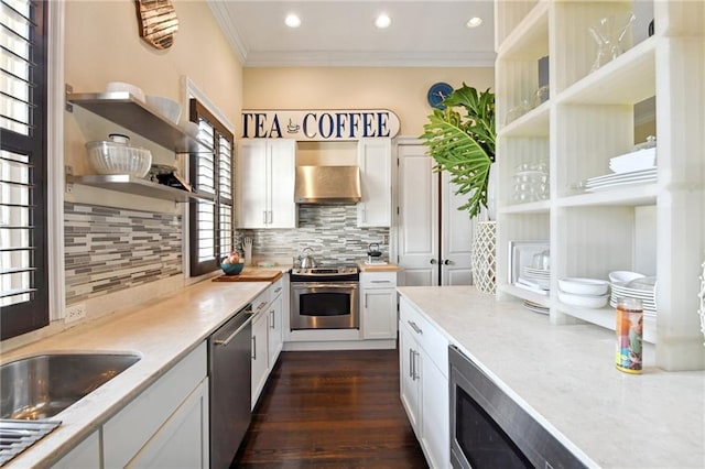 kitchen featuring dark wood-type flooring, crown molding, white cabinets, and appliances with stainless steel finishes