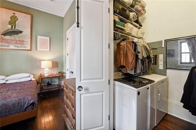 clothes washing area with dark hardwood / wood-style floors, ornamental molding, and washing machine and dryer