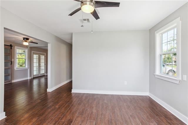 empty room with dark wood-type flooring and plenty of natural light