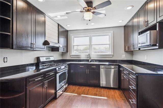 kitchen with appliances with stainless steel finishes, sink, ceiling fan, extractor fan, and dark hardwood / wood-style floors