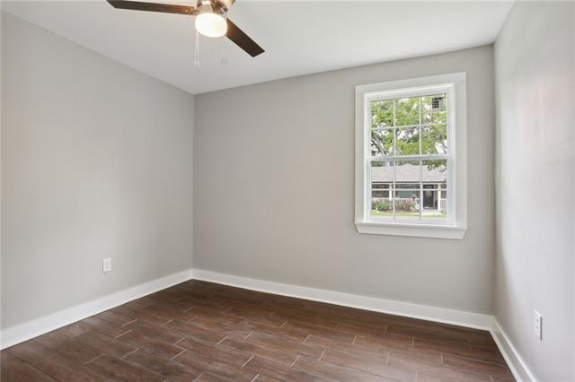 spare room with dark wood-type flooring and ceiling fan