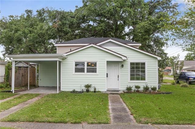 bungalow-style home featuring a carport and a front yard