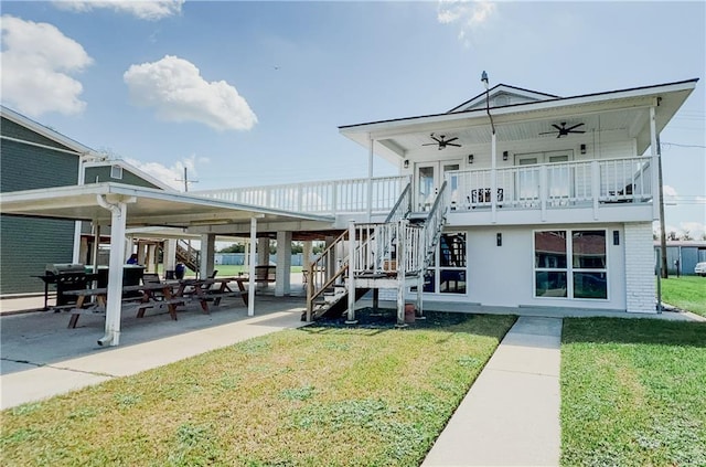 back of house featuring ceiling fan, a patio, and a lawn