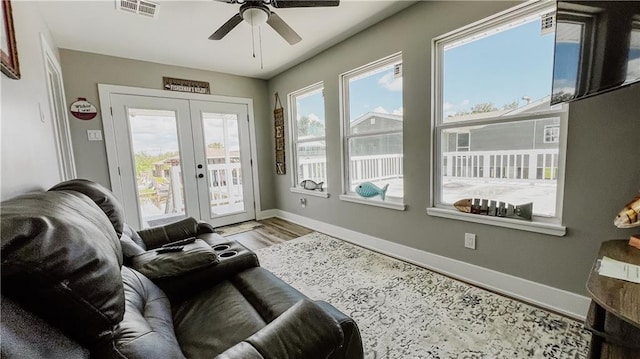 interior space with wood-type flooring, french doors, and ceiling fan