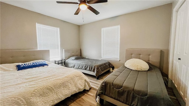 bedroom with wood-type flooring, a closet, and ceiling fan