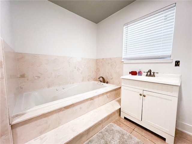 bathroom with tile patterned flooring, tiled bath, and vanity