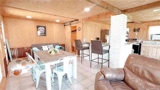 tiled dining room with a barn door, wooden ceiling, beam ceiling, decorative columns, and wooden walls