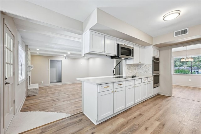 kitchen featuring decorative backsplash, light hardwood / wood-style floors, white cabinets, and appliances with stainless steel finishes