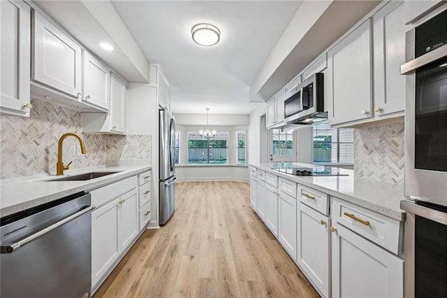 kitchen featuring light hardwood / wood-style floors, stainless steel appliances, sink, and white cabinetry