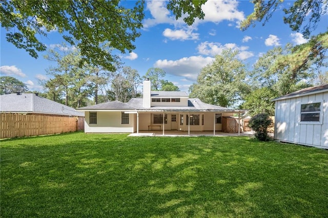 rear view of property with a patio and a lawn