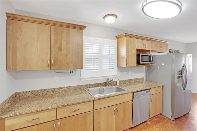 kitchen featuring light brown cabinetry, sink, light stone countertops, appliances with stainless steel finishes, and light tile patterned floors