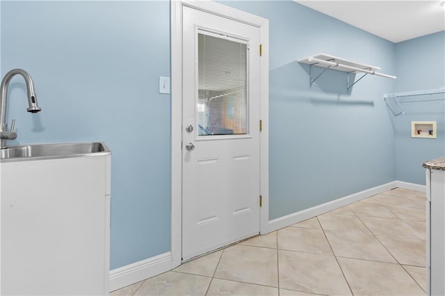 clothes washing area featuring light tile patterned floors, sink, and hookup for a washing machine