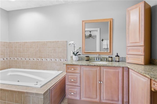 bathroom with vanity, ceiling fan, and tiled bath