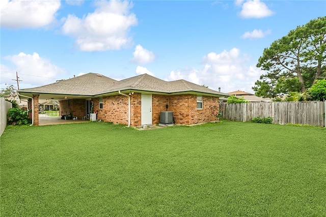 rear view of house with a lawn, a patio, and central air condition unit