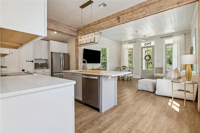 kitchen featuring pendant lighting, light hardwood / wood-style flooring, sink, stainless steel appliances, and white cabinets