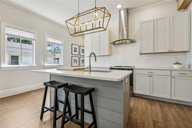 kitchen with wall chimney exhaust hood, sink, and white cabinetry