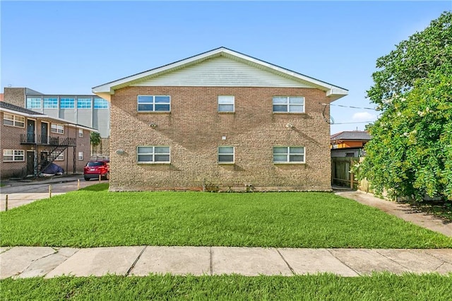 view of property exterior featuring brick siding and a yard