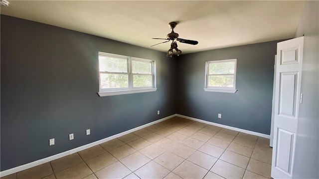 spare room featuring light tile patterned flooring, baseboards, and ceiling fan