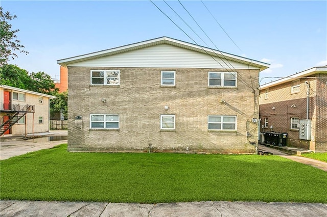 view of side of property featuring a yard and brick siding