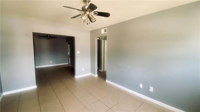 unfurnished room with light tile patterned floors, a ceiling fan, visible vents, and baseboards