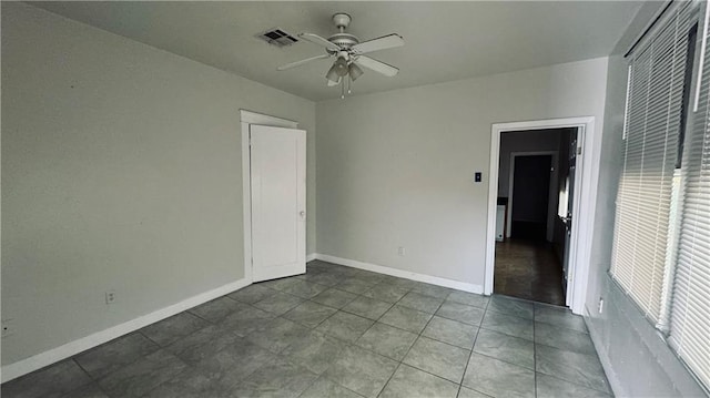 interior space with tile patterned floors, ceiling fan, and a closet