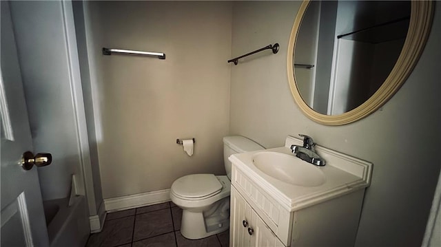 bathroom with a washtub, tile patterned floors, vanity, and toilet