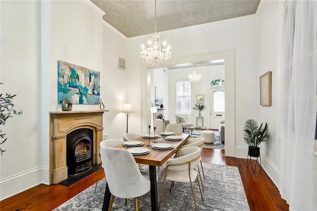 dining area with dark hardwood / wood-style floors and an inviting chandelier