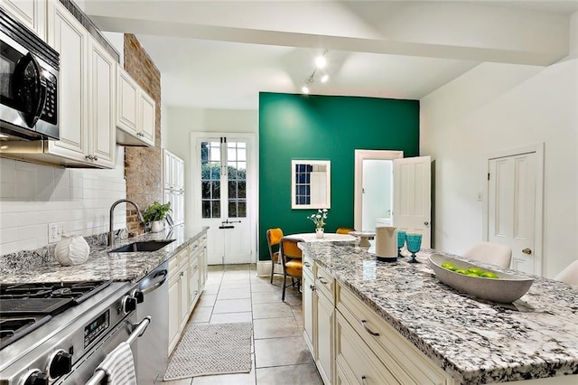 kitchen featuring a center island, sink, light stone countertops, and stainless steel appliances