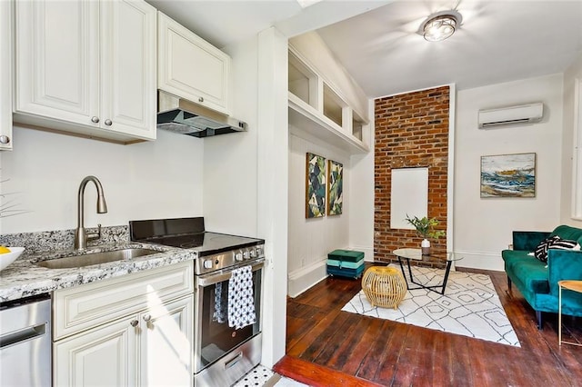 kitchen with white cabinetry, sink, appliances with stainless steel finishes, an AC wall unit, and dark hardwood / wood-style flooring