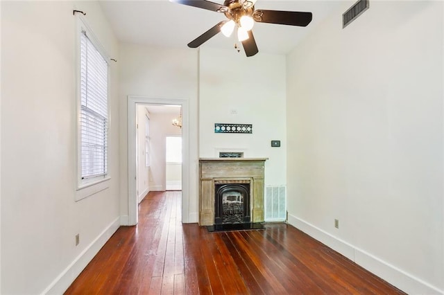 unfurnished living room with dark hardwood / wood-style flooring and ceiling fan