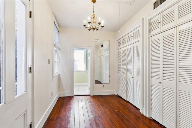 entryway with dark hardwood / wood-style floors and an inviting chandelier