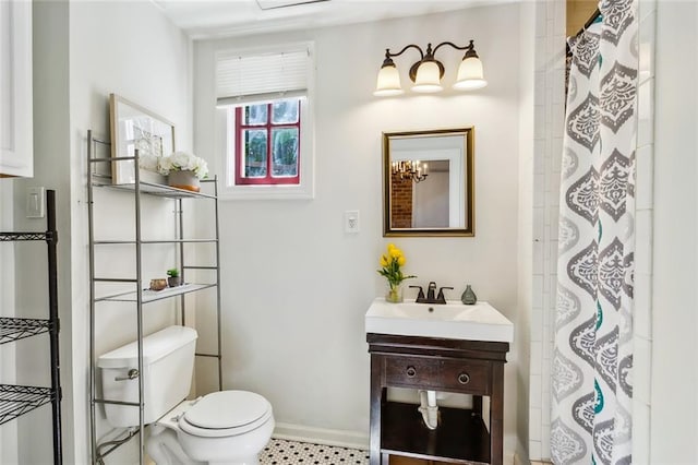 bathroom with a chandelier, vanity, and toilet