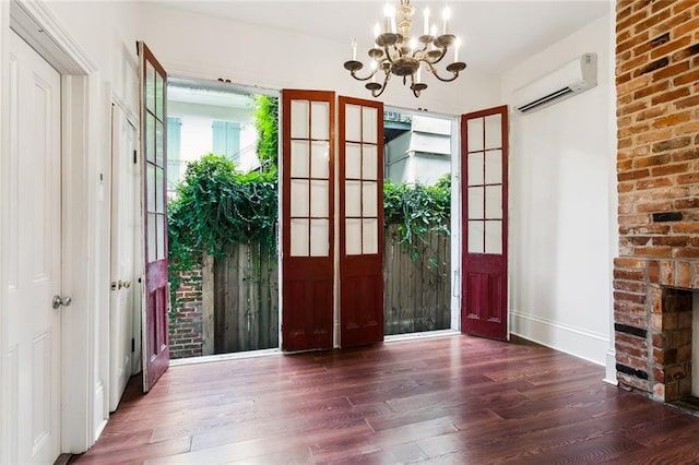 entryway with dark wood-type flooring, a chandelier, a healthy amount of sunlight, and a wall mounted air conditioner