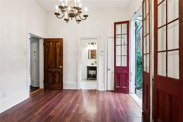 foyer with dark wood-type flooring and a chandelier