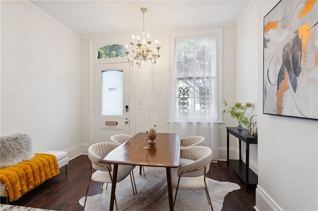 dining area with ornamental molding, dark wood-type flooring, and a notable chandelier