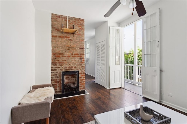 interior space with ceiling fan, dark hardwood / wood-style floors, and a fireplace