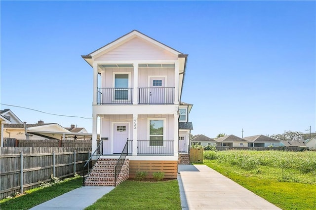 view of front of property featuring a porch, a balcony, and a front lawn