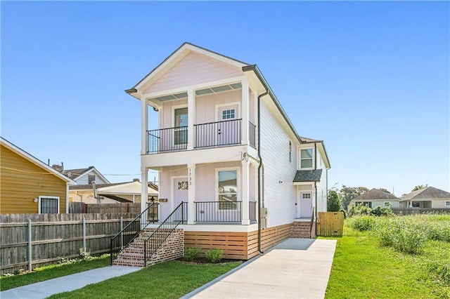 view of front of home with a balcony, a front lawn, and covered porch