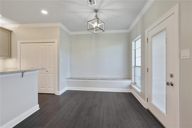 unfurnished dining area featuring dark wood-type flooring, ornamental molding, and an inviting chandelier