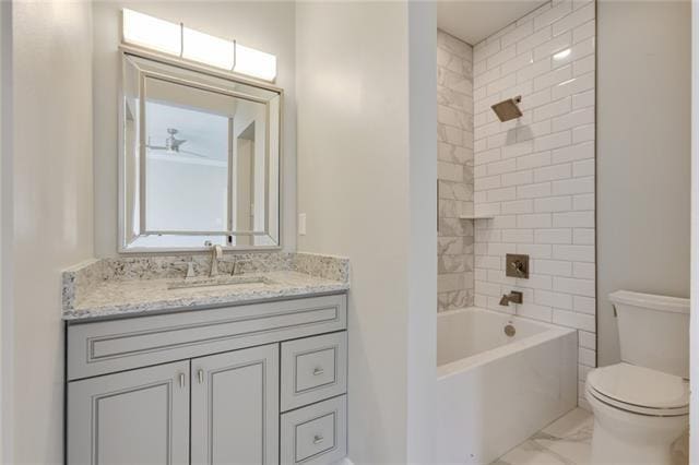 full bathroom with tiled shower / bath combo, vanity, and toilet