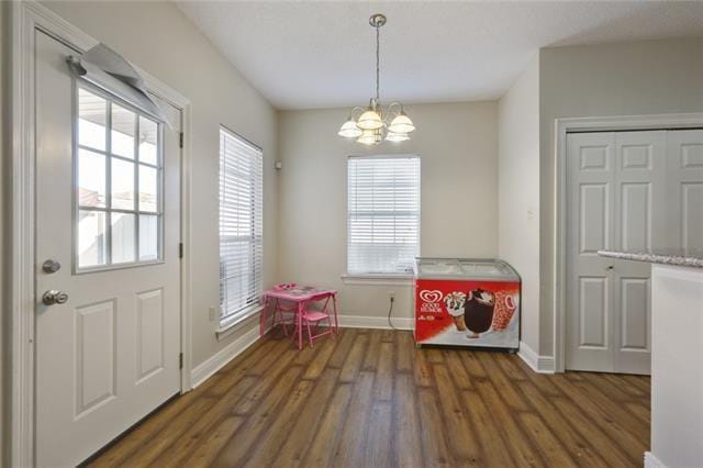 rec room with a notable chandelier, plenty of natural light, and dark hardwood / wood-style flooring