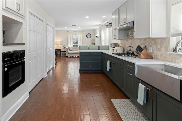 kitchen with stainless steel gas cooktop, oven, kitchen peninsula, dark hardwood / wood-style floors, and white cabinets