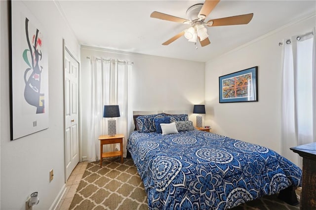 bedroom featuring ornamental molding, ceiling fan, and a closet