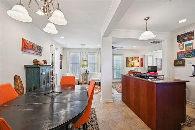 dining area featuring ceiling fan with notable chandelier, crown molding, and light tile patterned floors