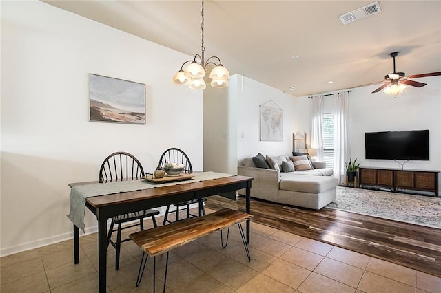 dining space featuring ceiling fan with notable chandelier and hardwood / wood-style flooring