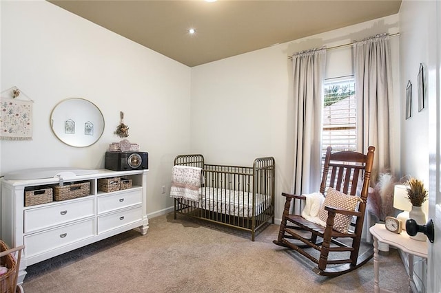 bedroom featuring a crib and light carpet