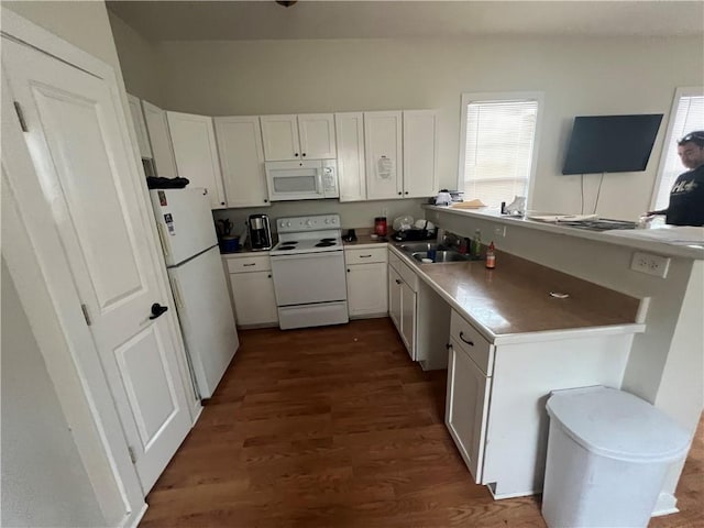 kitchen with dark wood-type flooring, sink, white appliances, and white cabinetry