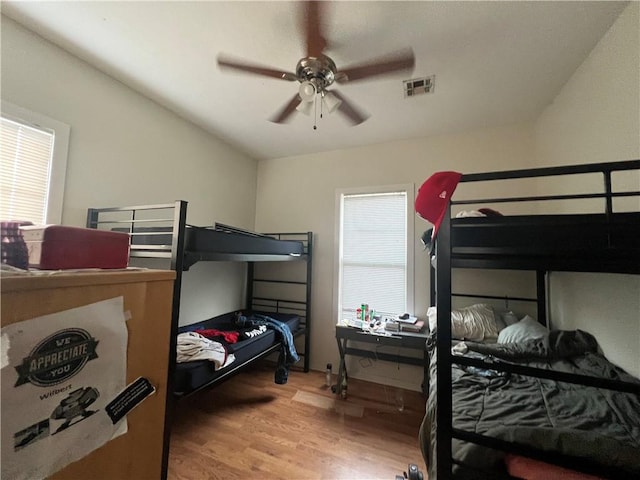 bedroom featuring multiple windows, ceiling fan, and light hardwood / wood-style flooring