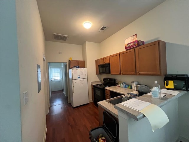 kitchen featuring black appliances, dark wood-type flooring, sink, and a kitchen breakfast bar